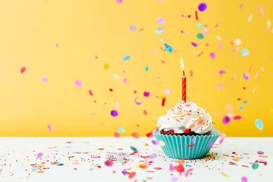 cupcake with birthday candle and confetti