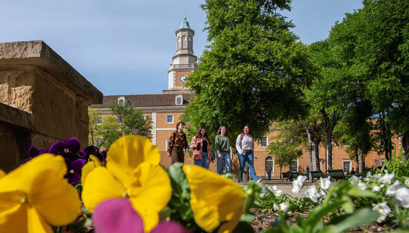 Hurley building with students walking and flowers in the foreground