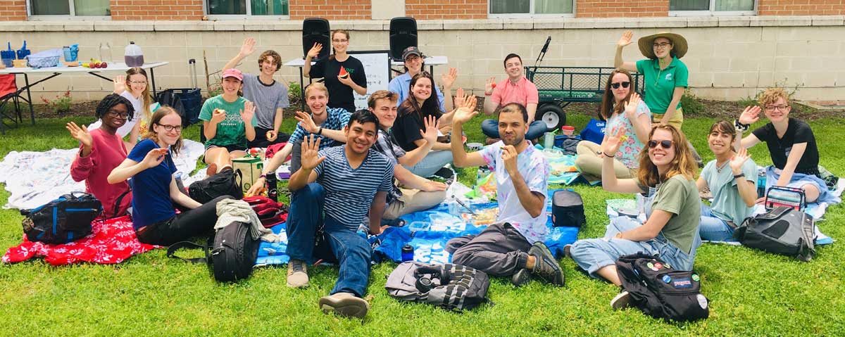 Students waiving at a picnic