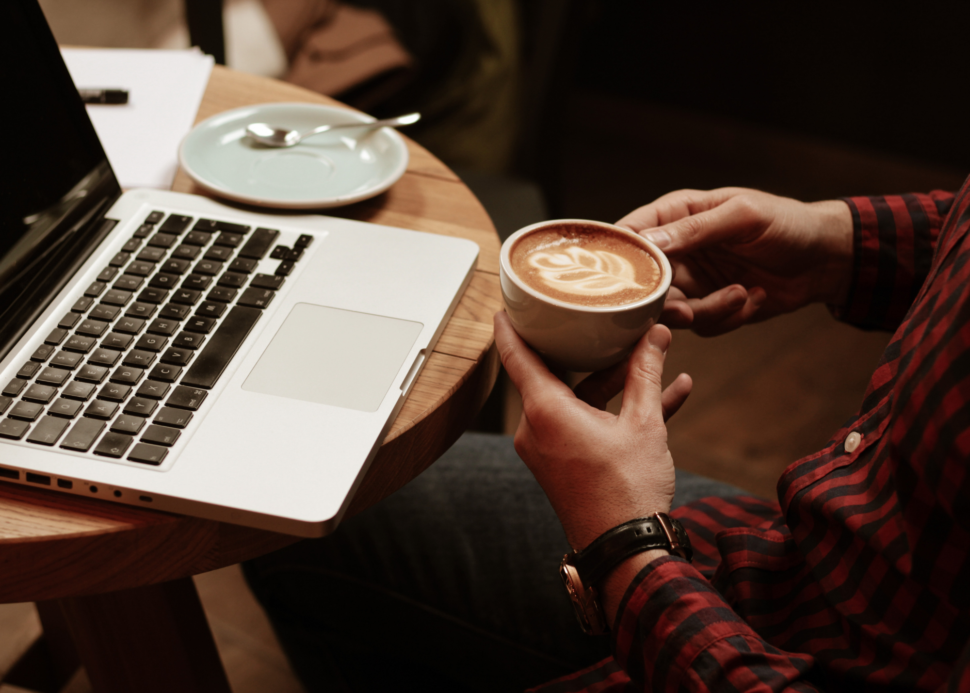 Photo of student at a coffee shop working on laptop