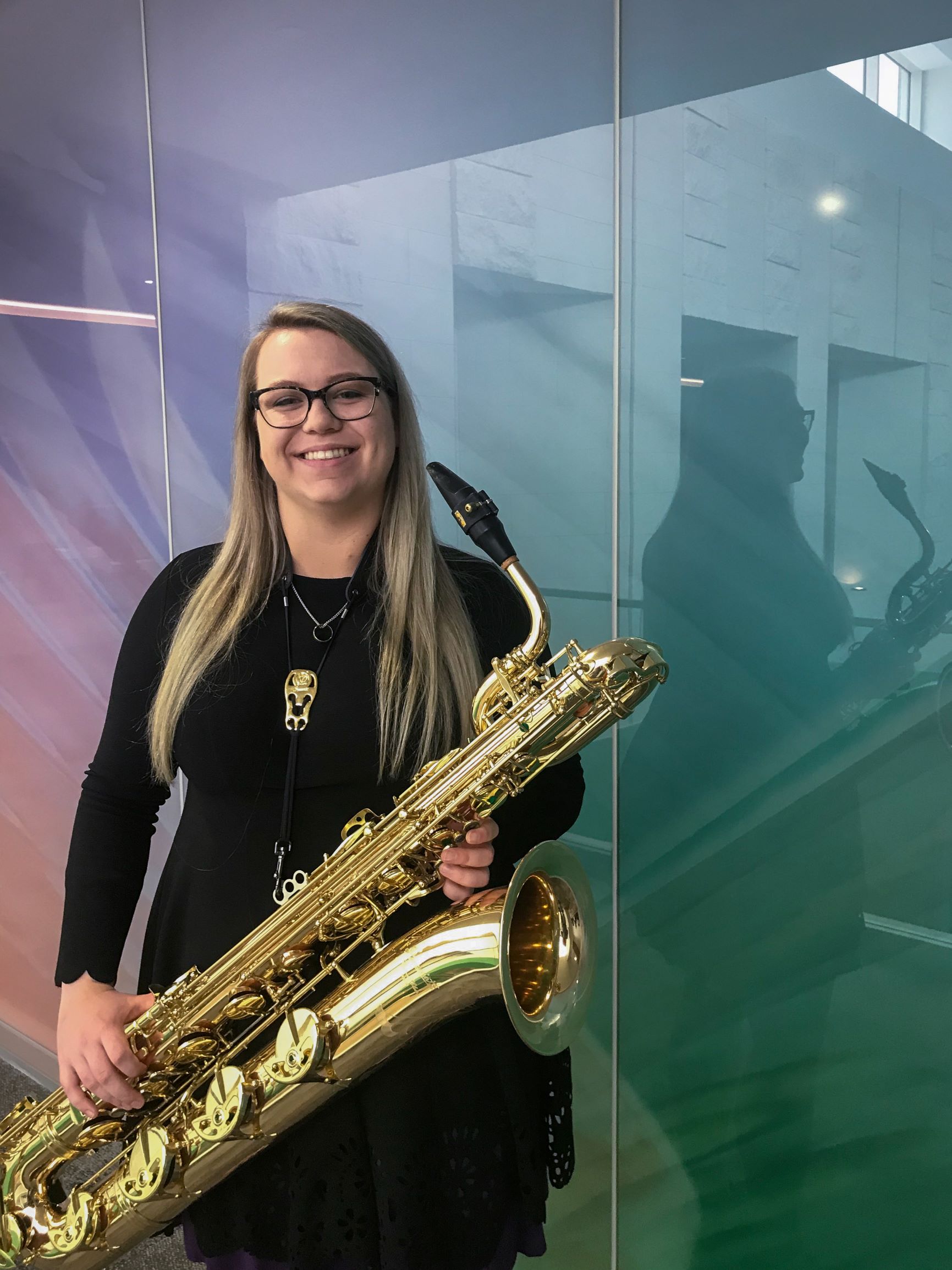 Beige Caldwell Posing For A Photo With A Saxaphone